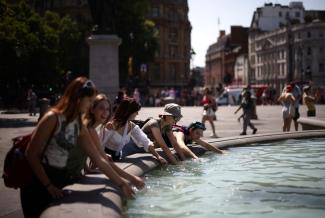 People cool off in a water fountain during a heatwave, at Trafalgar Square in London, Britain, July 19, 2022. (Credit: REUTERS/Henry Nicholls)