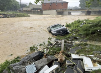 In this photo released by the The Weather Channel, a vehicle ends up in a stream after a heavy rain near White Sulphur Springs, W.Va., on June 24, 2016. Photo: Chris Dorst, The Weather Channel via AP