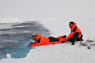 University of Delaware postdoctoral researcher Baoshan Chen (pictured left) takes water samples from a melting pond on ice in the northern Arctic Ocean basin while his Chinese collaborator assists. Photo: Di Qi and Zhongyong Gao, Third Institute of Oceanography, State Oceanic Administration of China.