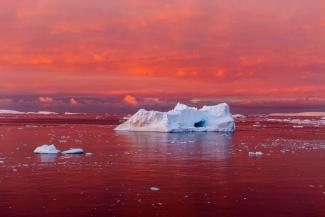 A startling sunset reddens the Lemaire Channel, off the west coast of the Antarctic Peninsula. The continent’s coastal ice is crumbling as the sea and air around it warm. Photo: Camille Seaman