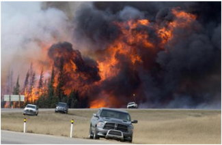 In this May 7, 2016 file photo, a wildfire burns south of Fort McMurray, Alberta. A dry and blistering hot northern Alberta is burning and doing so unusually early in the year, but that’s only the latest of many gargantuan fires on an Earth that’s grown hotter with more extreme weather. Photo: Jonathan Hayward, The Canadian Press, AP