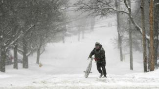 Jake Robinson walks his bike during a winter storm in Auburn, New York, Tuesday, March 14, 2017. A blustery, late-season storm clobbered the Northeast with sleet and heavy snow Tuesday, crippling much of the Washington-to-Boston corridor after a stretch of unusually mild winter weather that had people thinking spring was already here. Photo: Kevin Rivoli, The Citizen via AP