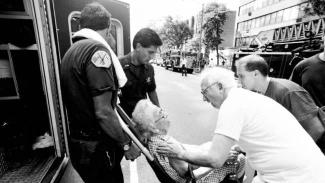 A 101-year-old woman is assisted after being overcome by heat later in the summer when an electrical fire knocked out the power in her apartment building. Photo: Chicago Tribune