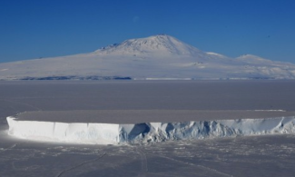 An iceberg lies in the Ross Sea with Mount Erebus in the background near McMurdo Station in Antarctica, November 11, 2016. A sheet of meltwater lasted for as long as 15 days in some places on the surface of the Ross Ice Shelf, the largest floating ice platform on Earth, during the Antarctic summer of 2016. Photo: Agence France-Presse via Getty Images