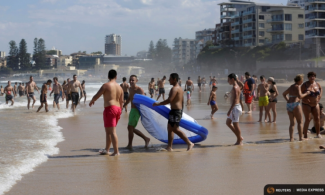Sydneysiders take refuge from sweltering conditions alongside apartments at Sydney's North Cronulla Beach during a heatwave along Australia's east coast on Feb. 11, 2017. Photo: Jason Reed, Reuters
