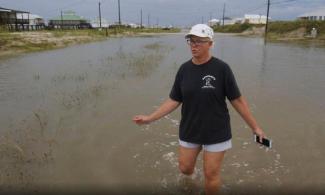 Susan Jones walks through a flooded road from Tropical Storm Gordon, Wednesday, Sept. 5, 2018, in Dauphin Island, Ala. Photo: Dan Anderson, AP