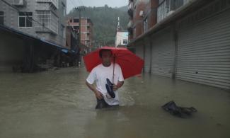 A man wades through a flooded street in Ningde, China, on Sunday, August 9th. Photo: CNN