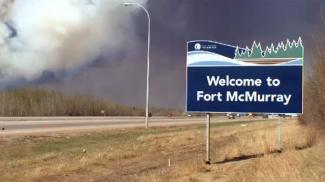 Wildfire smoke blankets the sky behind the 'Welcome to Fort McMurray' sign on May 18, 2016. Photo: CTV Edmonton