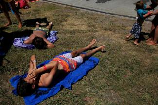 Julian Schmilinsky, 13, lower left, wipes sweat from his face while laying in the sunshine with John-Paul Schmilinsky, 12, upper left. Photo: Leah Millis, The Chronicle