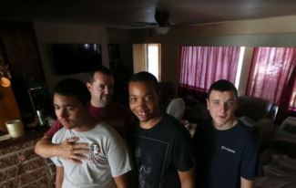 John Hettinger, the owner and manager of Twin Lakes mobile home park, stands inside his home with his sons John-Michael 15, from left, Jason, 22, Shawn 19 who all have a form of autism. The power remains out at Twin Lakes where there are 48 tenants and, according the Hettinger, city utility dispatchers have stated they will be some of the last to be serviced. Photo: Joe Rondone, Democrat