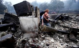 Sheri Marchetti-Perrault and James Benton embrace as they sift through the ruins of their home, which was destroyed by the McKinney fire. (Credit: Luis Sinco / Los Angeles) Times)