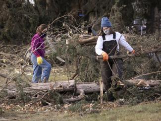 Residents clear fallen trees Thursday, after a strong storm swept through Hartland, Minn. A powerful storm system swept across the Great Plains and Midwest, bringing hurricane-force wind gusts and spawning reported tornadoes in Nebraska, Iowa and Minnesota. (Credit: Christian Monterrosa/AP)